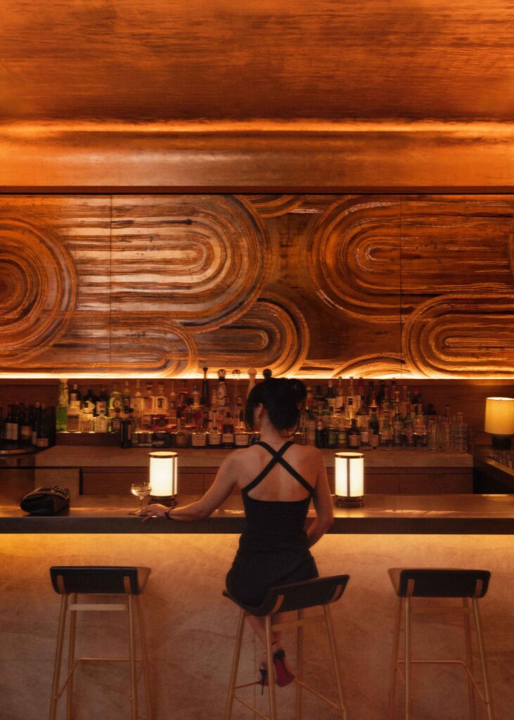 A woman sitting at the bar at Bar Pendry Manhattan West