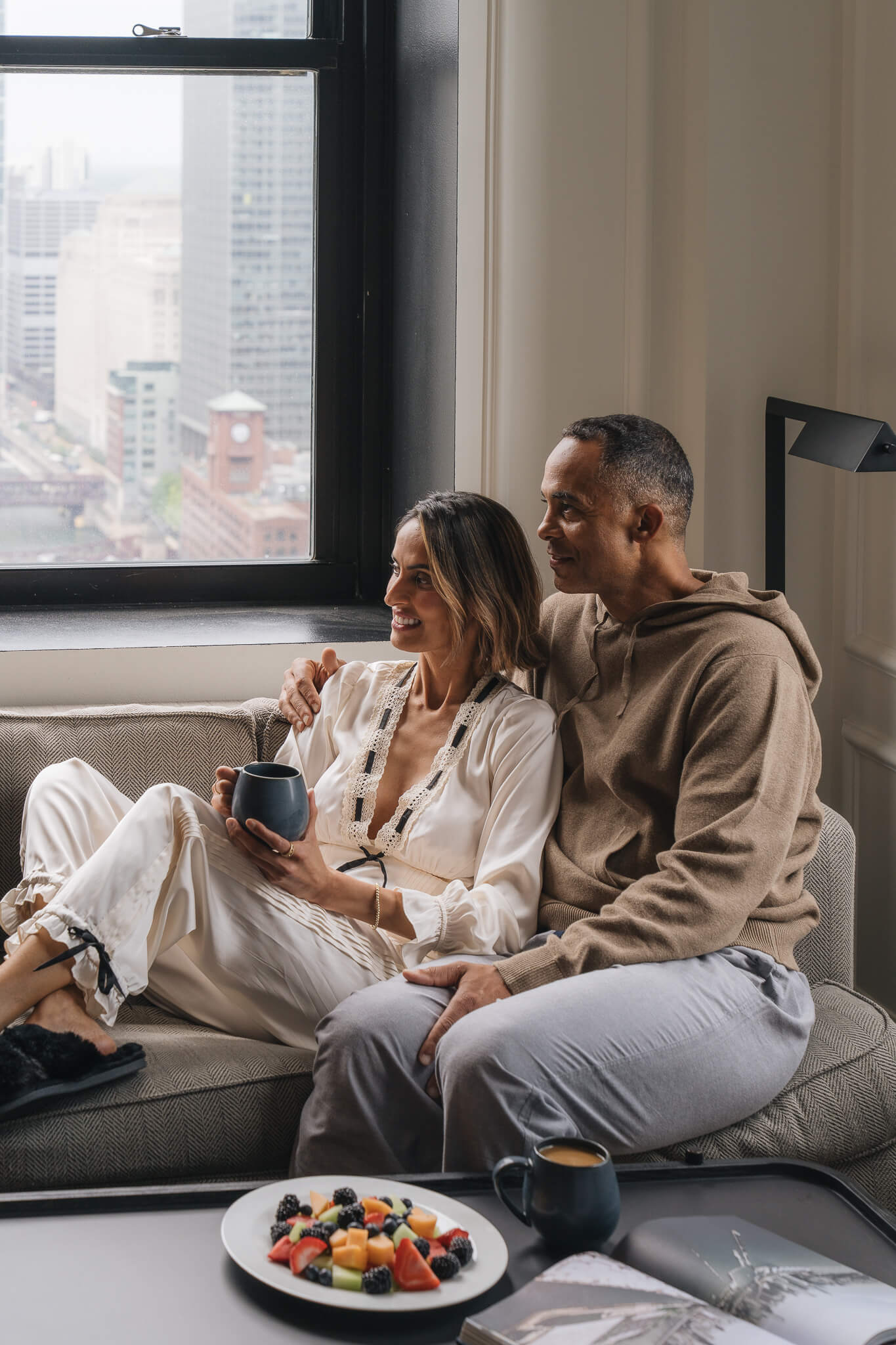 A couple lounging in their guestroom at Pendry Chicago.