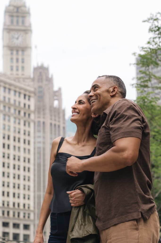 Smiling couple looking up while exploring a city