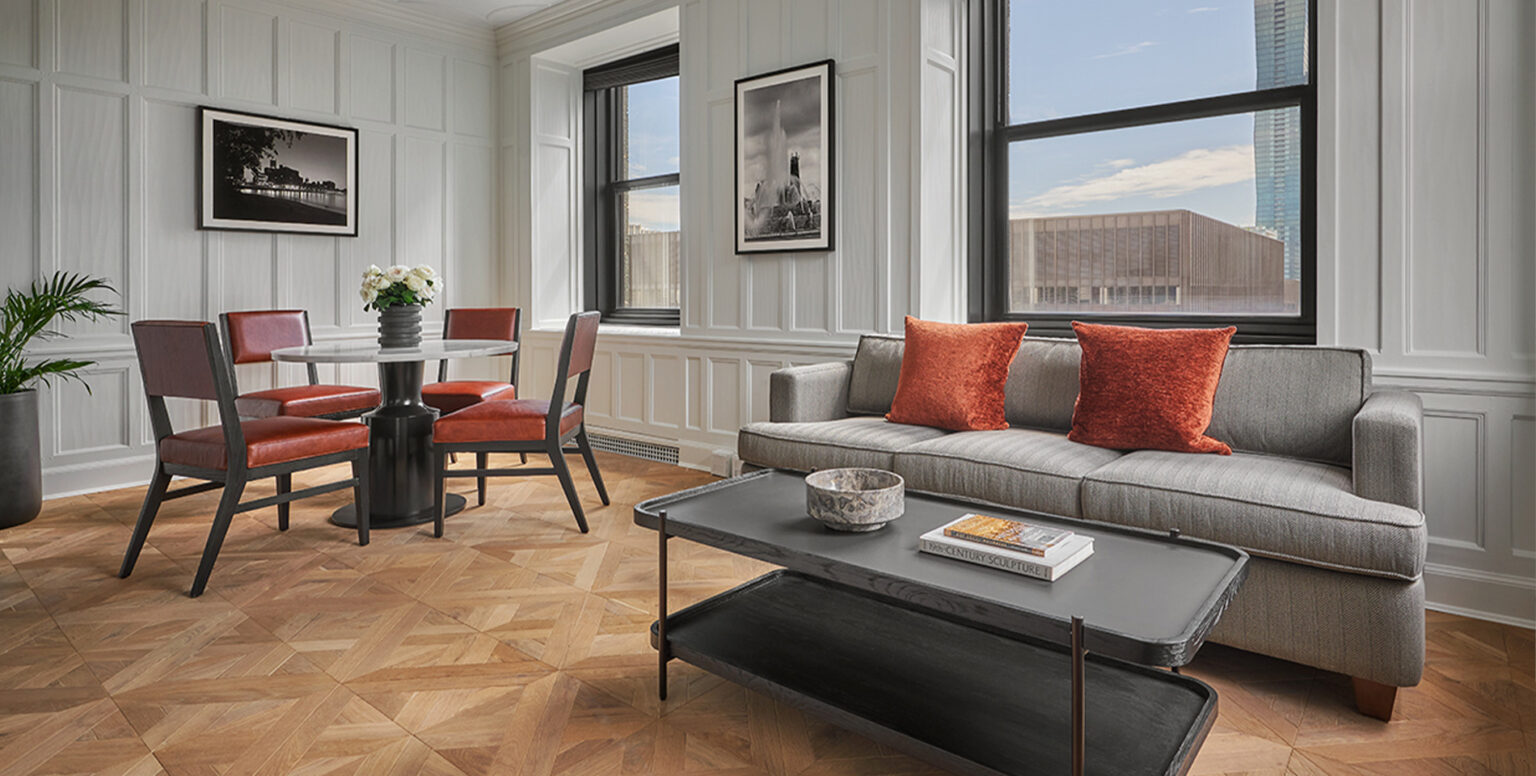 A living room with a dining table, couch and coffee table at Pendry Chicago