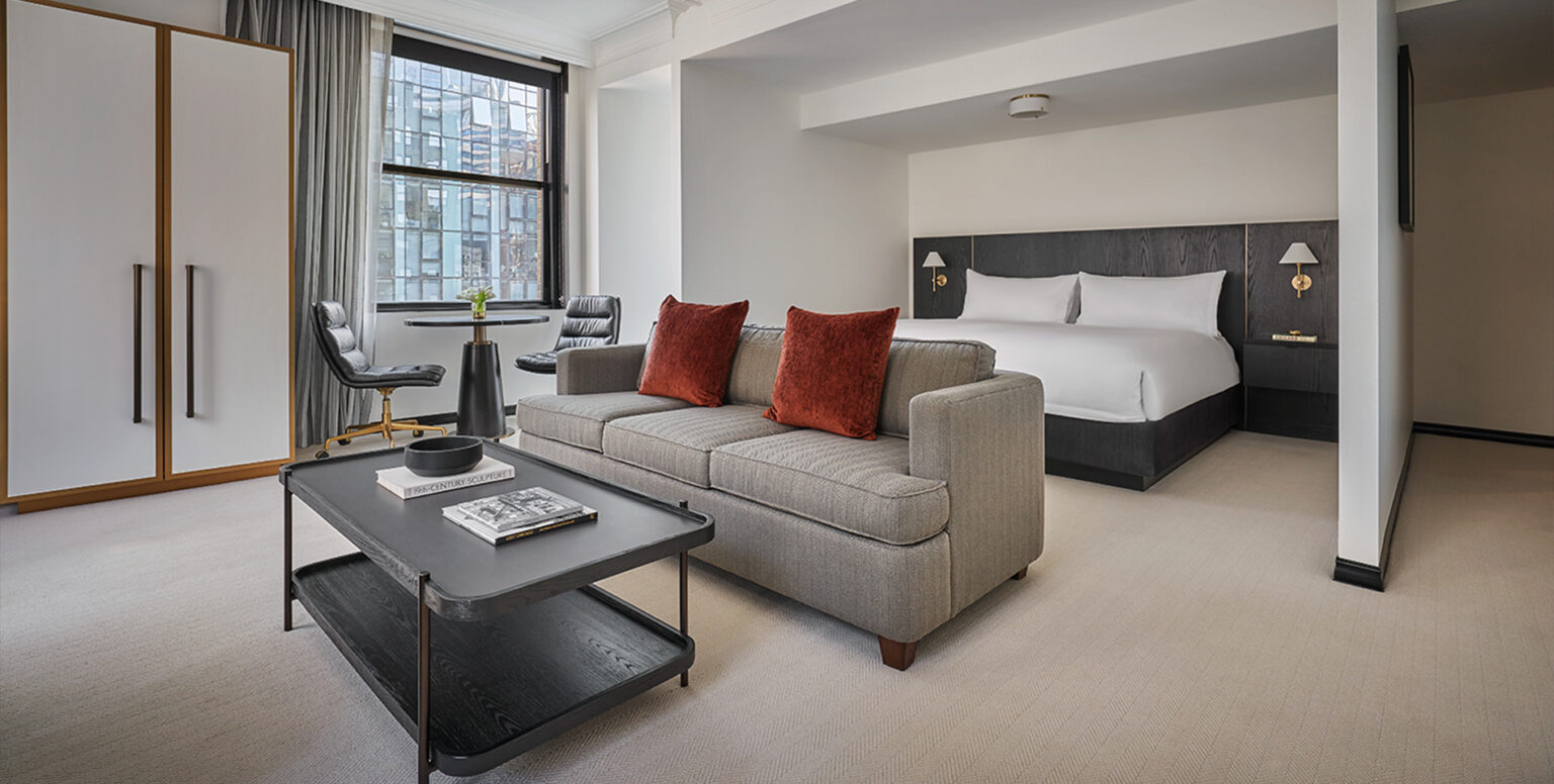 A Studio Suite with a king bed, couch and coffee table at Pendry Chicago