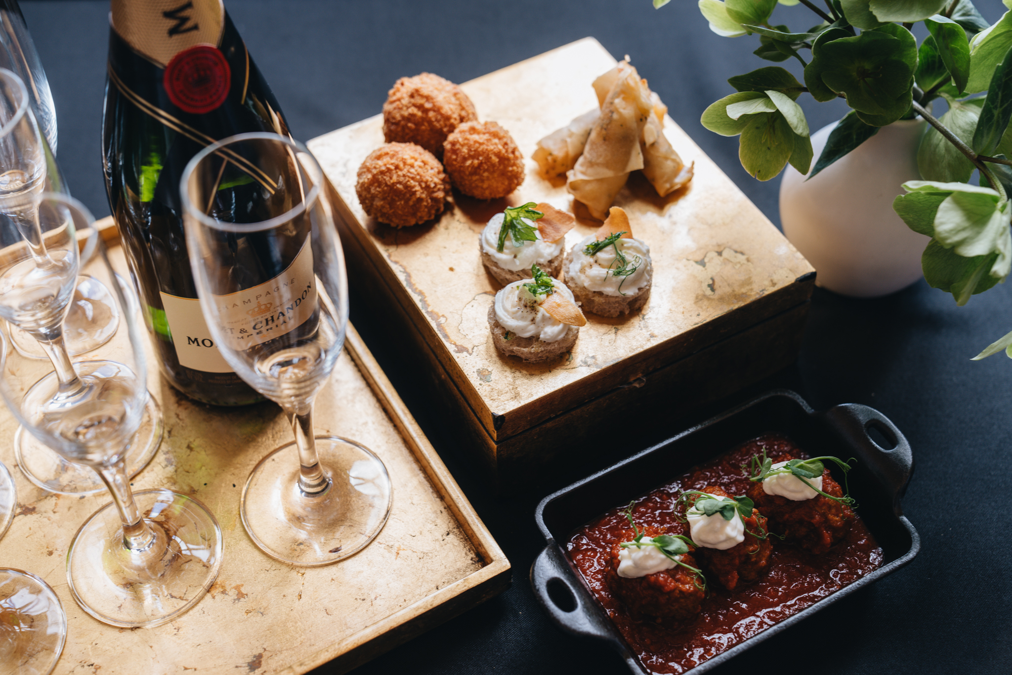 Appetizers next to champagne glasses and a bottle of champagne