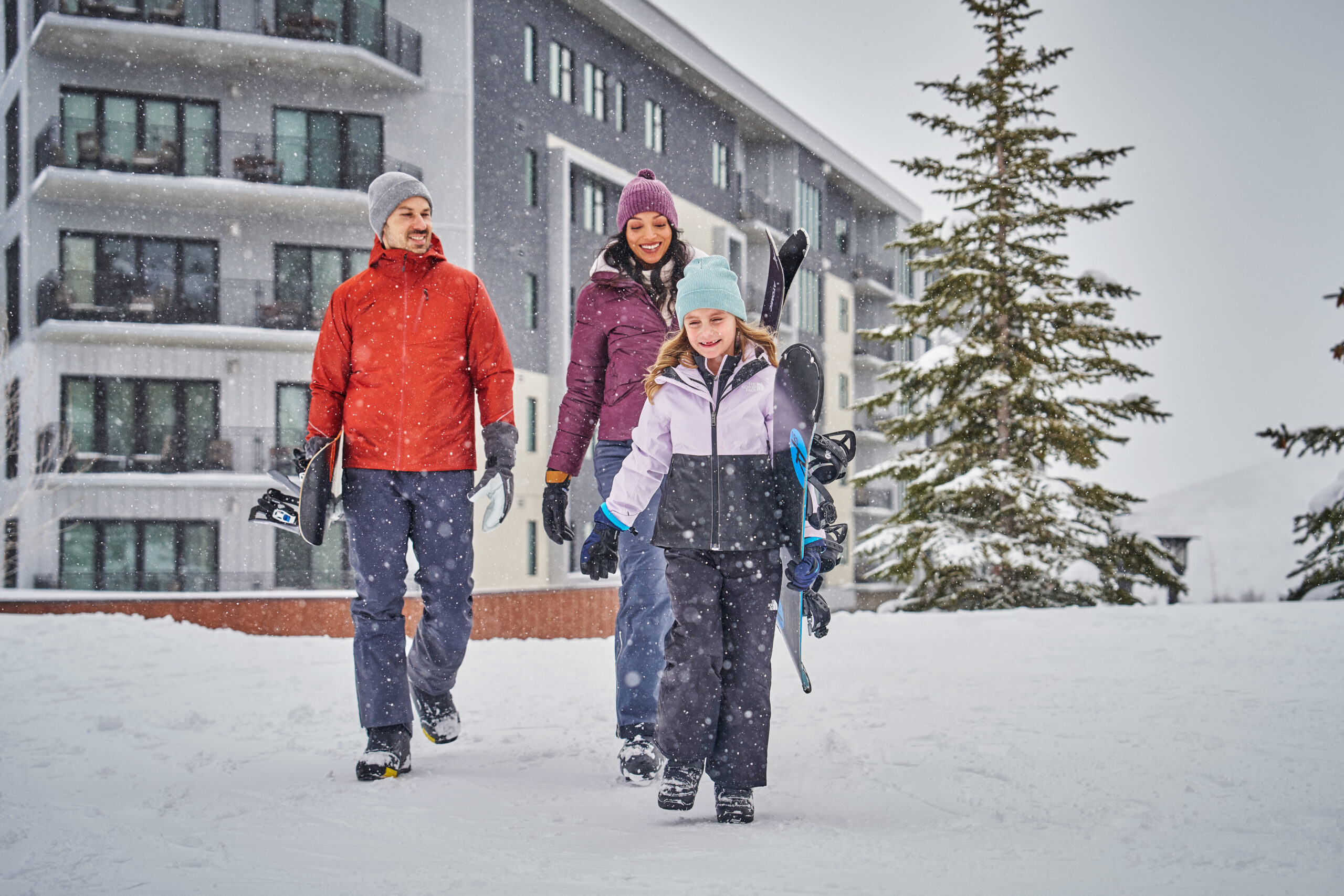 A family trekking through the snow at Pendry Park City.