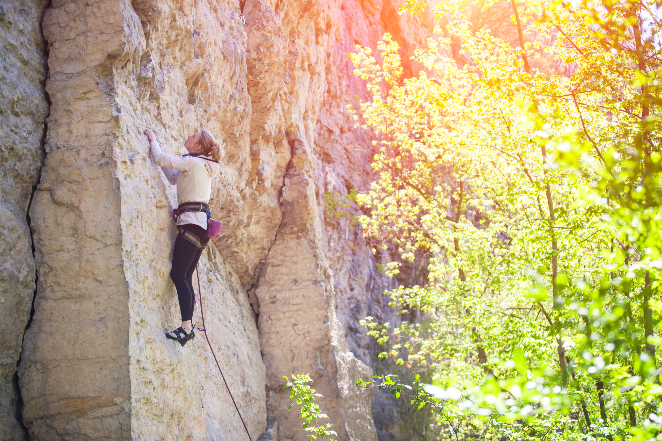 A woman rock climbing up a wall