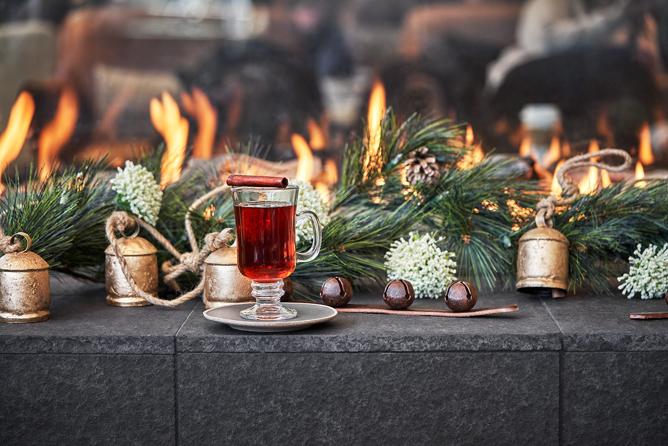 A festive holiday scene with a glass of mulled wine garnished with a cinnamon stick