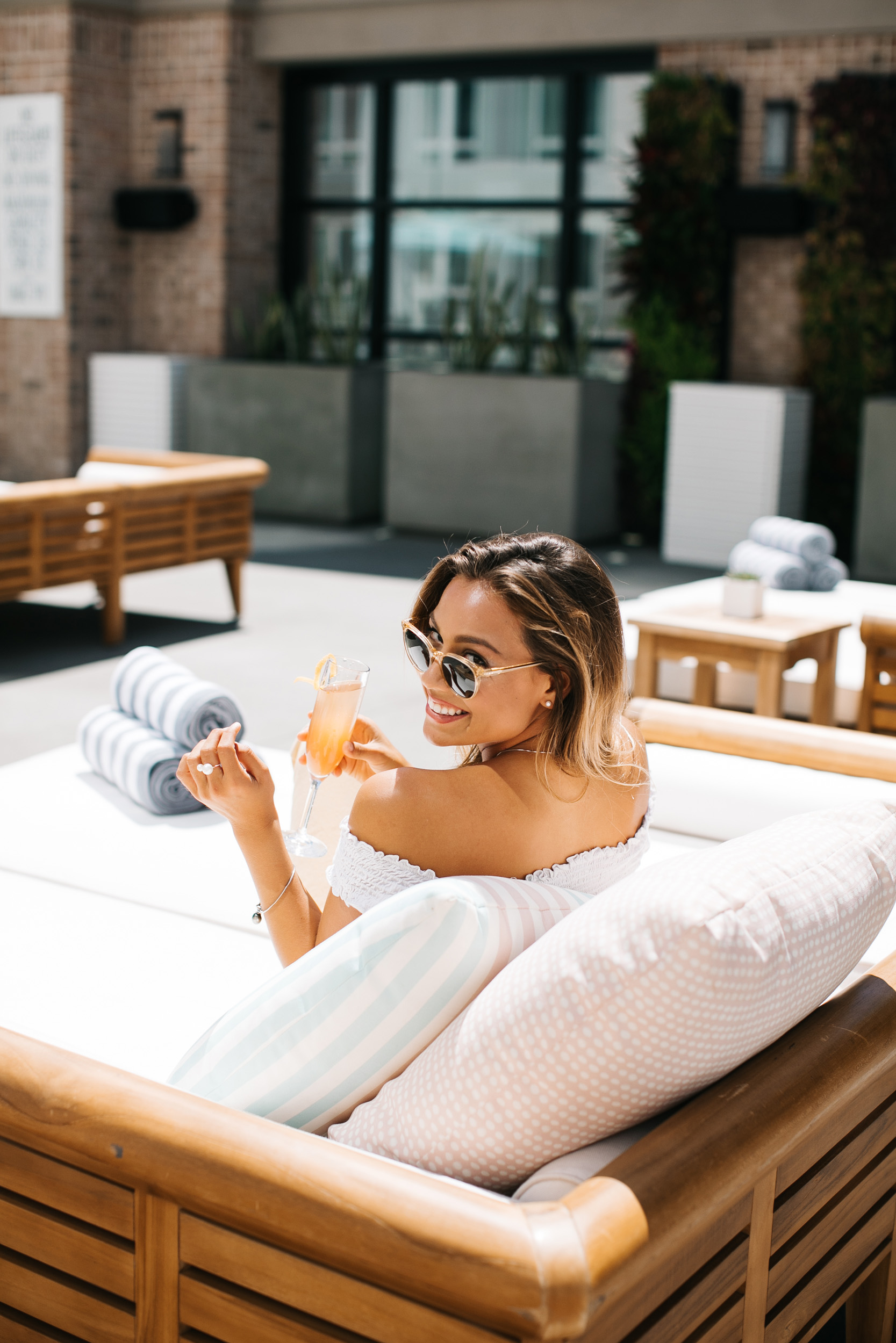 woman drinking cocktail on sunny rooftop pool in San Diego Gaslamp District hotel