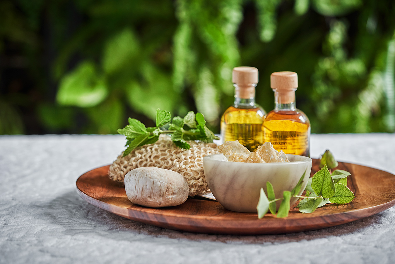 A spa tray with oil bottles and mint leaves at Pendry San Diego