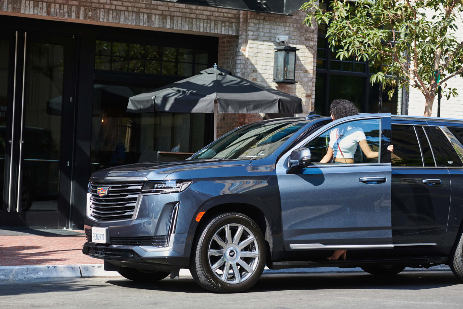 A woman getting into a Cadillac at Pendry San Diego