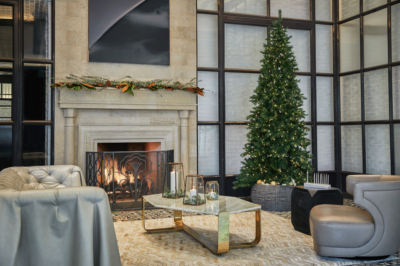 Lounge with a lit fireplace, Christmas tree, and modern holiday decor