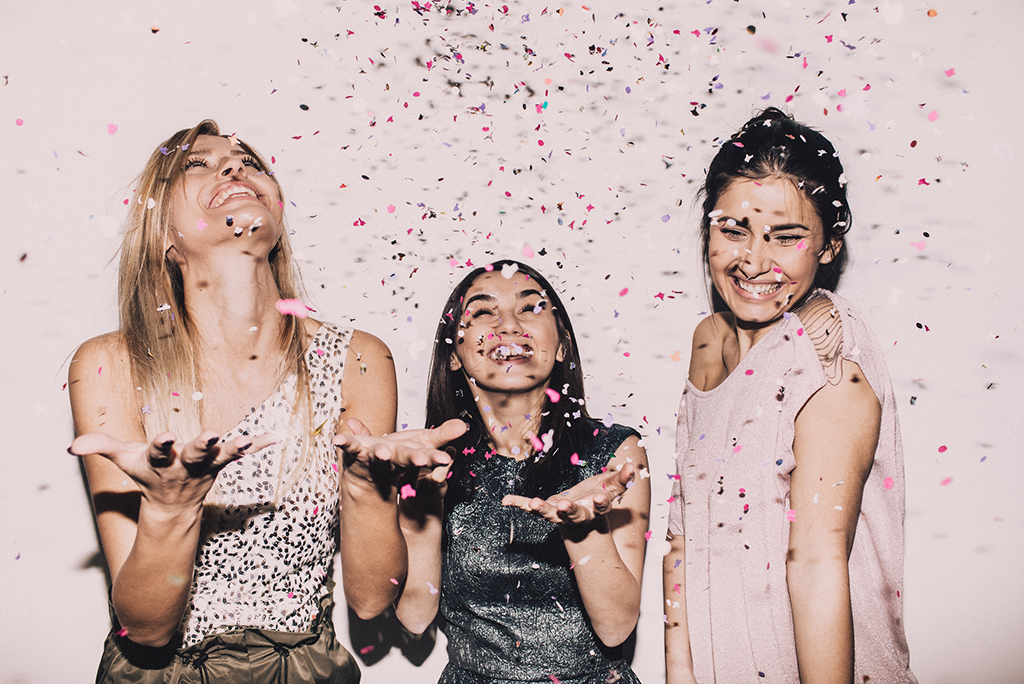 A group of friends celebrating a birthday with confetti.