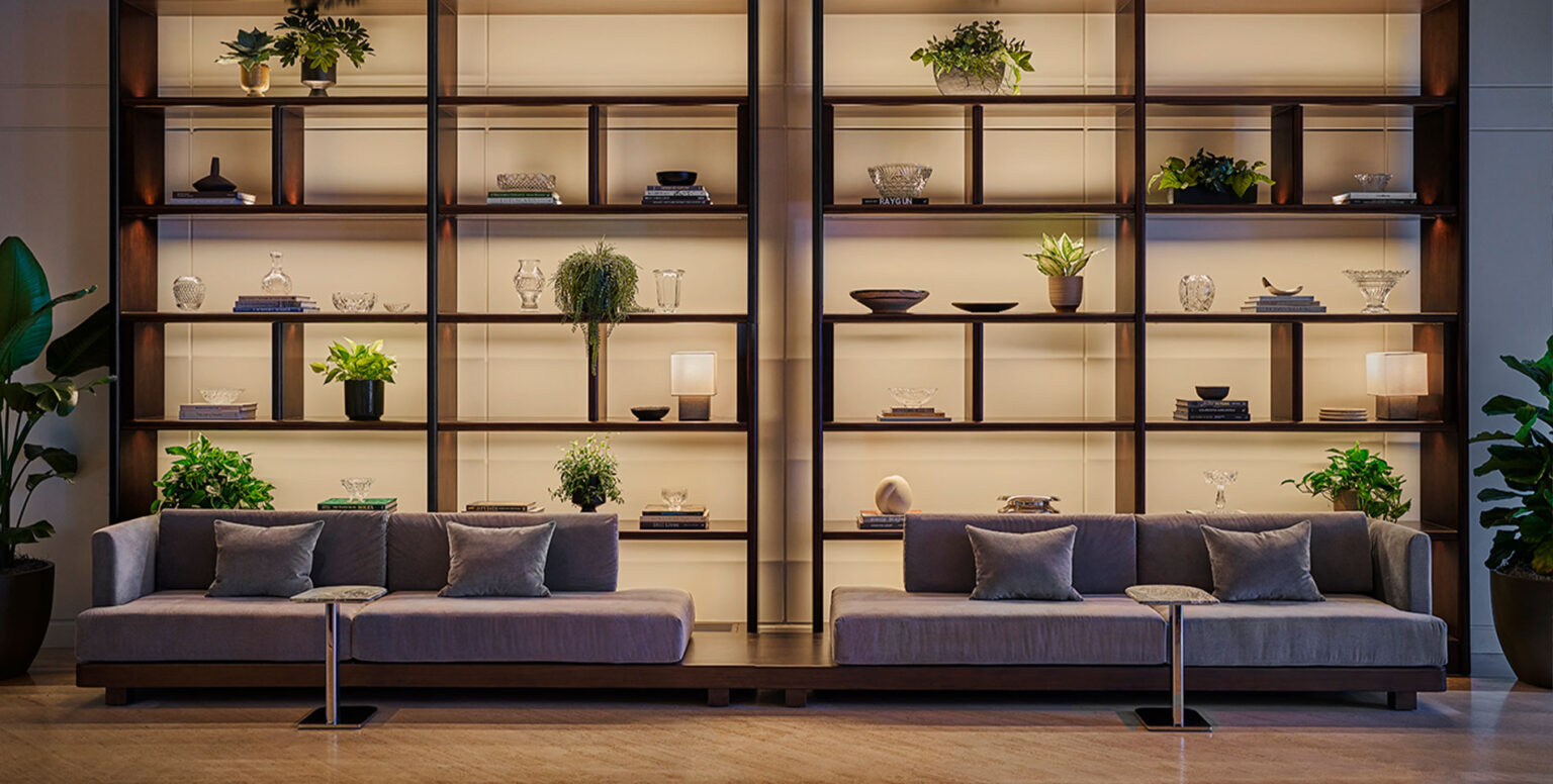 A sitting area with a bookshelf behind the couches at Pendry Newport Beach
