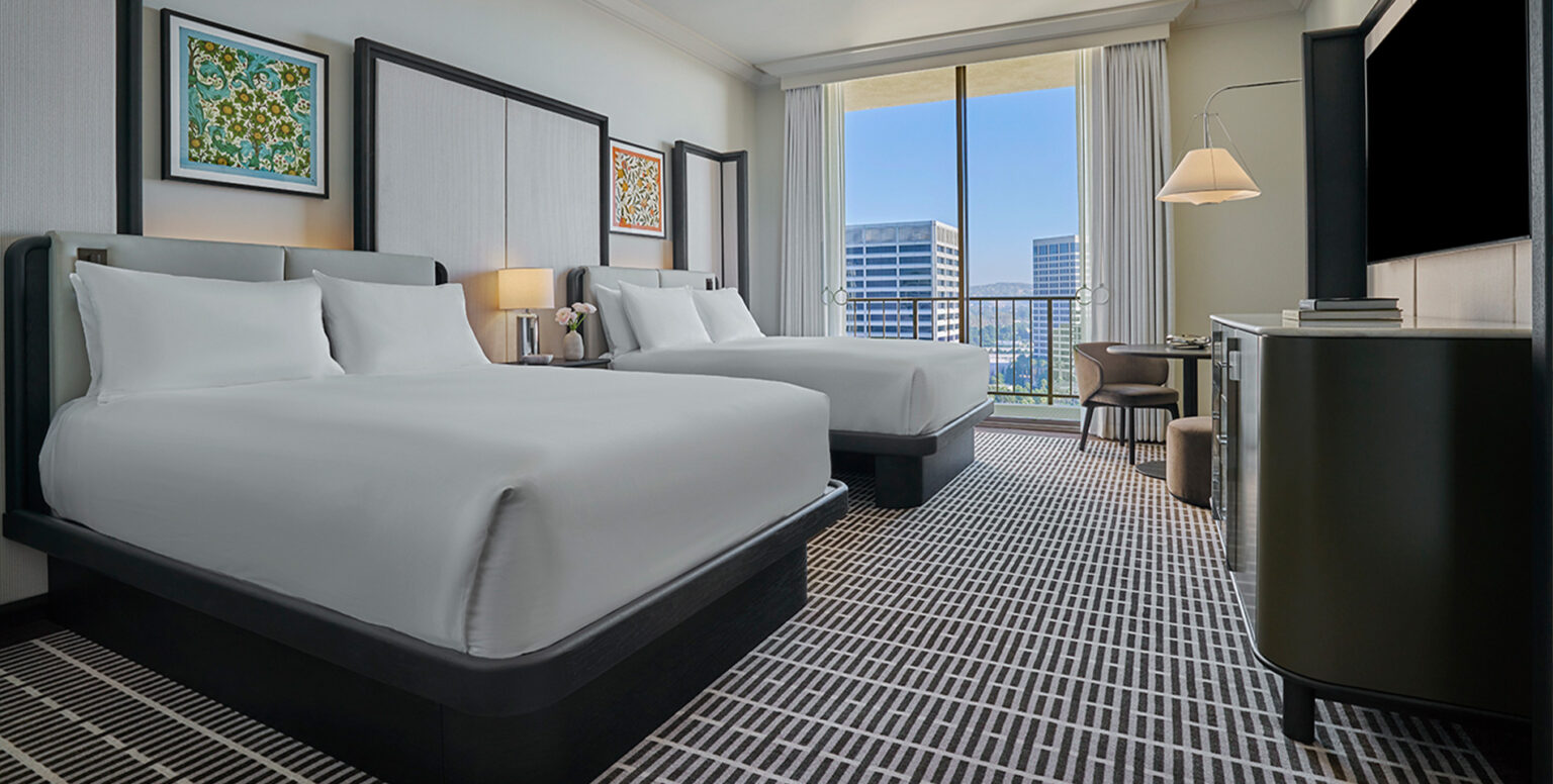 Two queen beds in a guestroom at Pendry Newport Beach