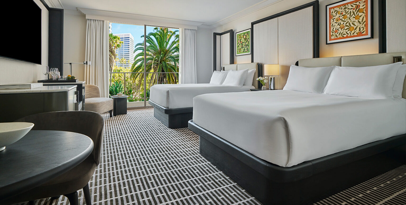 A double queen bedroom with a balcony at Pendry Newport Beach