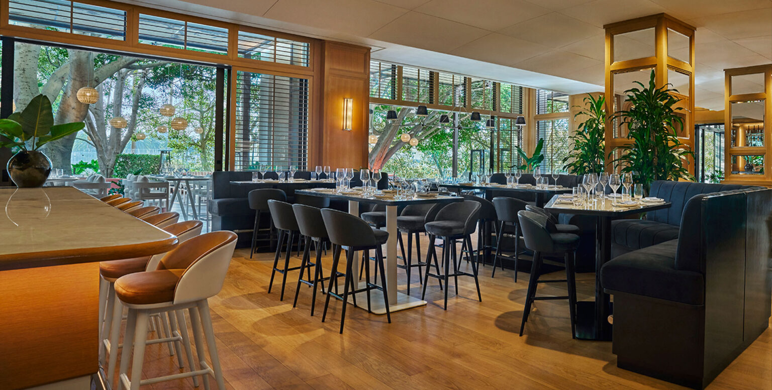 Chairs and tables with wine glasses on them at SET Steak & Sushi in Pendry Newport Beach