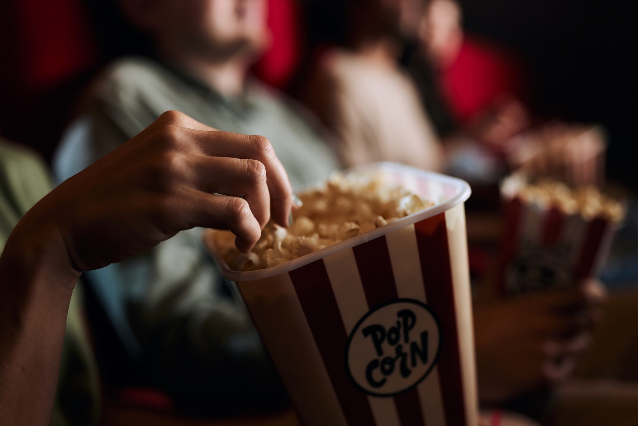 Close up of eating popcorn in cinema.