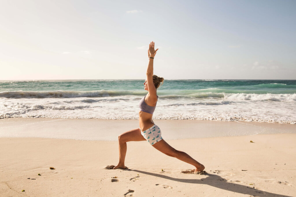 A woman stretching on the beach at Pendry Barbados.