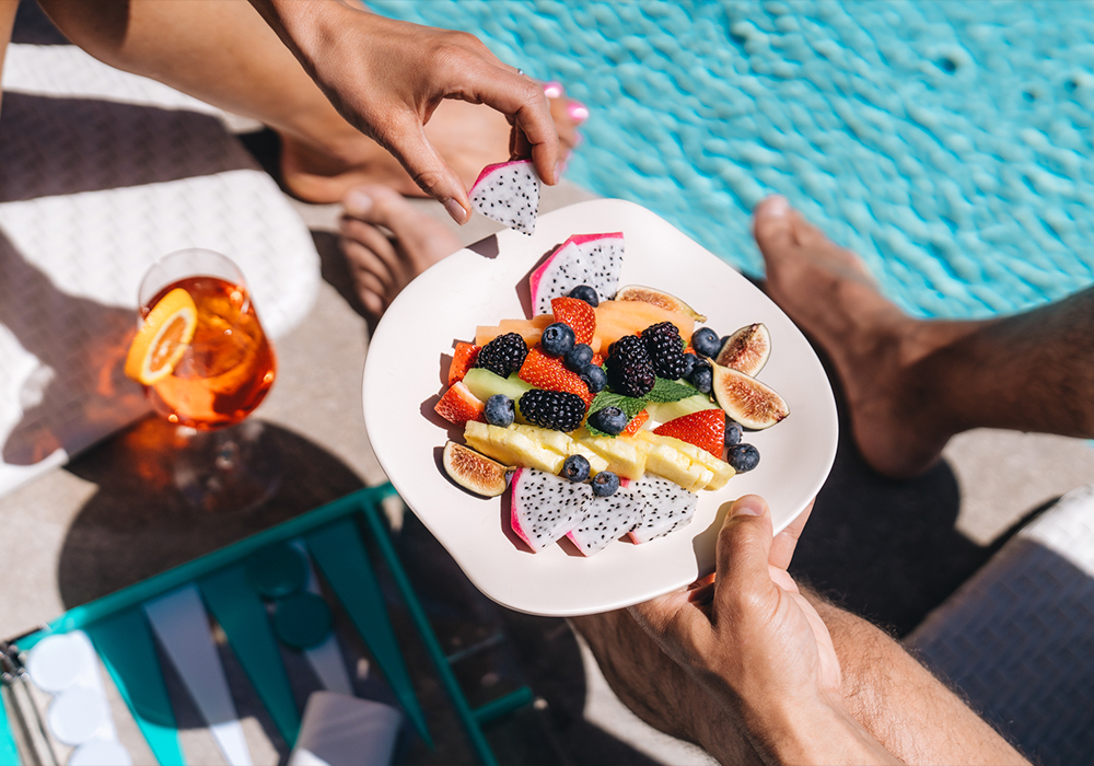 Couple eating fruit by the pool