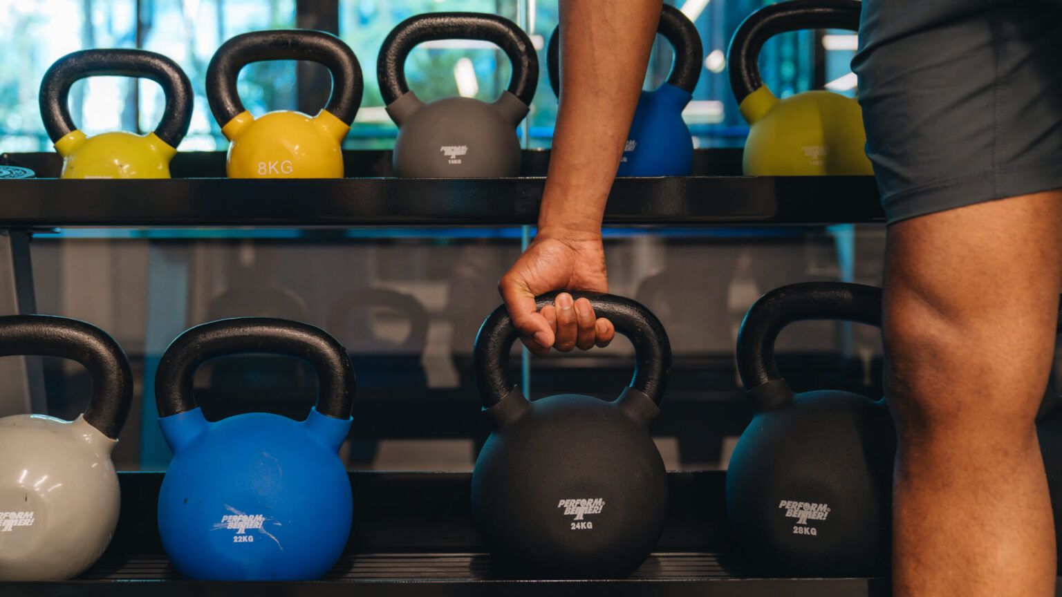 A man lifting weights in the fitness center at Pendry Baltimore.