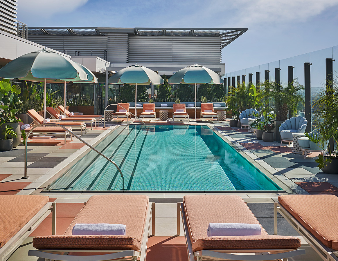 View of pool with lounge chairs and umbrellas at Pendry West Hollywood, a luxury weho hotel