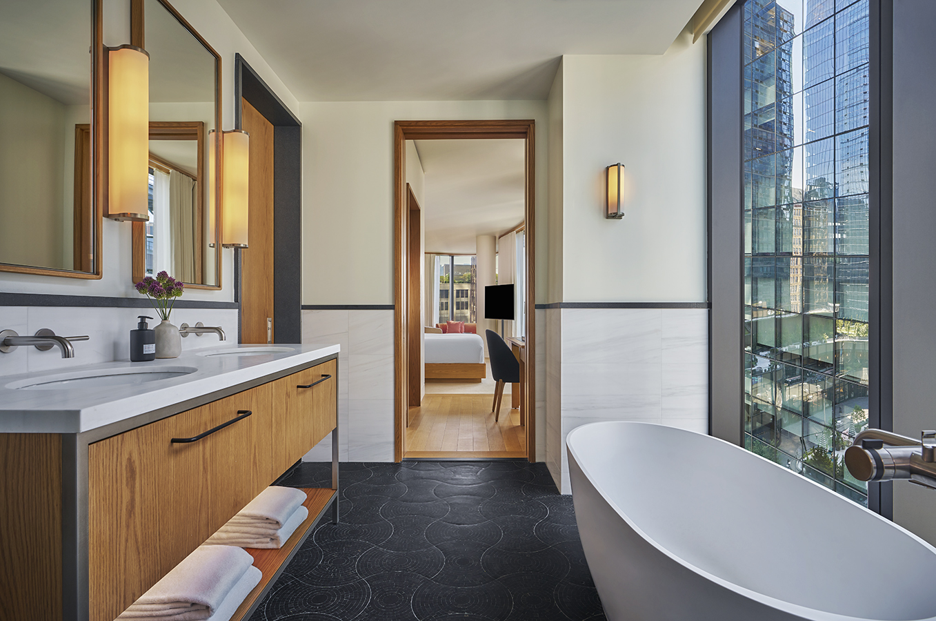 A guestroom bathroom with a vanity and a bathtub at Pendry Manhattan West.