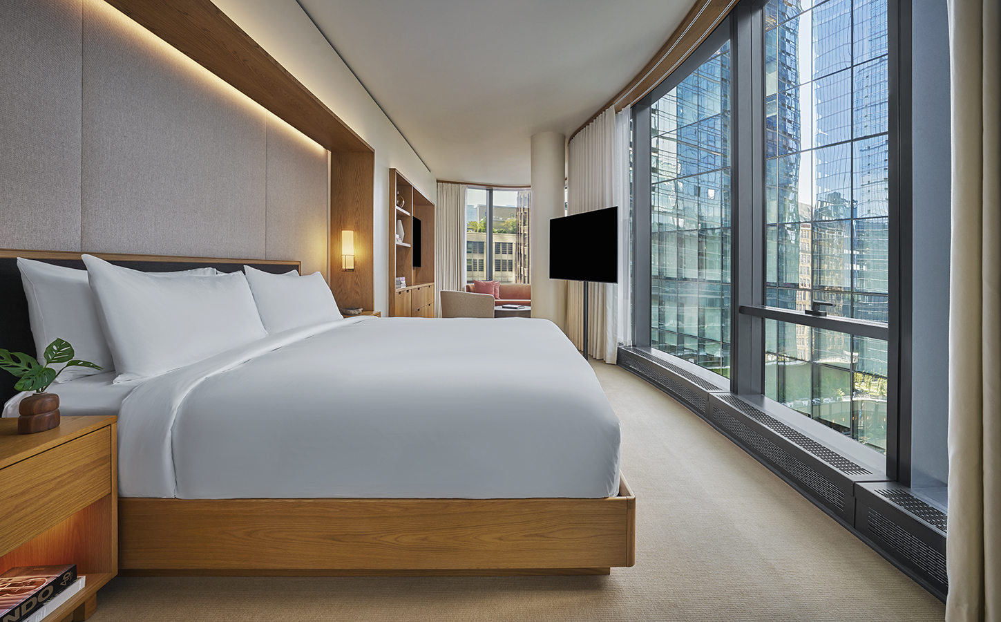 A king bed in a guestroom with floor to ceiling windows at Pendry Manhattan West.