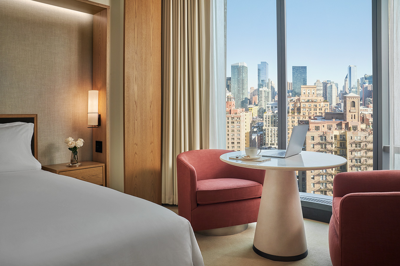 A red chair and a table in a guestroom at Pendry Manhattan West.