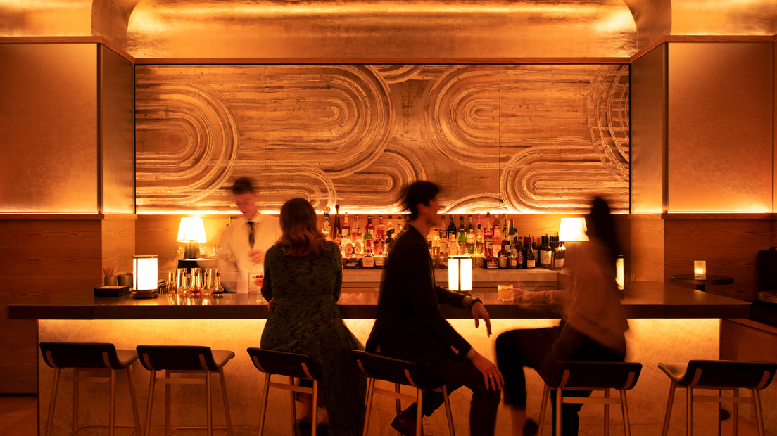 Blurry shot of people sitting at the bar at Pendry Manhattan West.