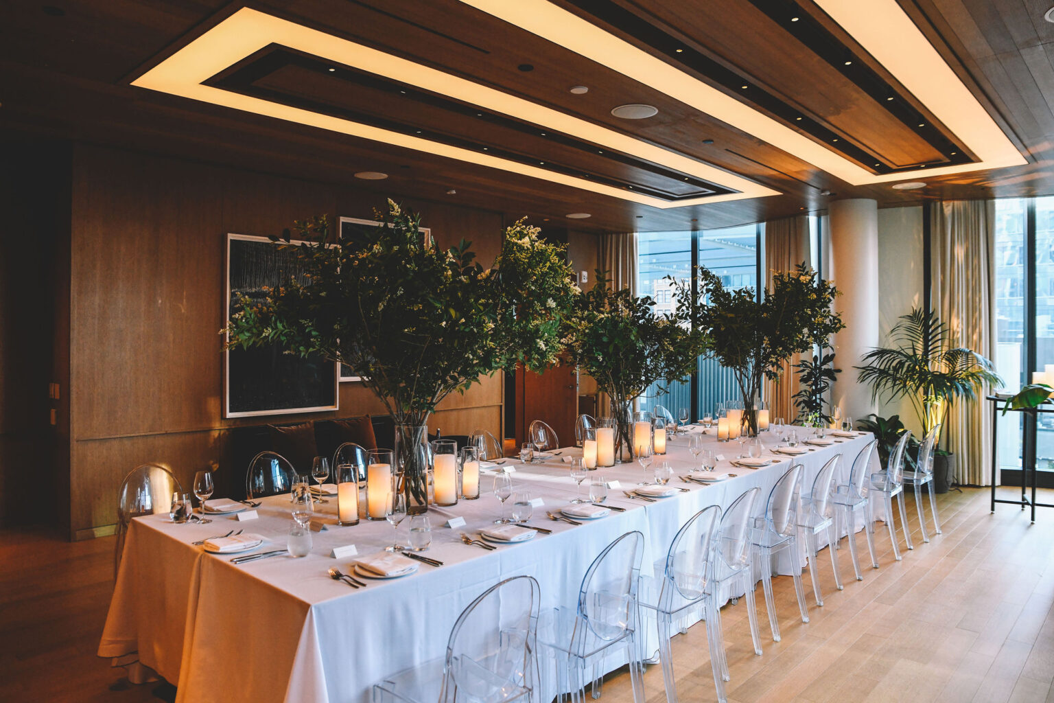 Event dining setup in The Gallery with tall greenery centerpieces and candlelight at Pendry Manhattan West.