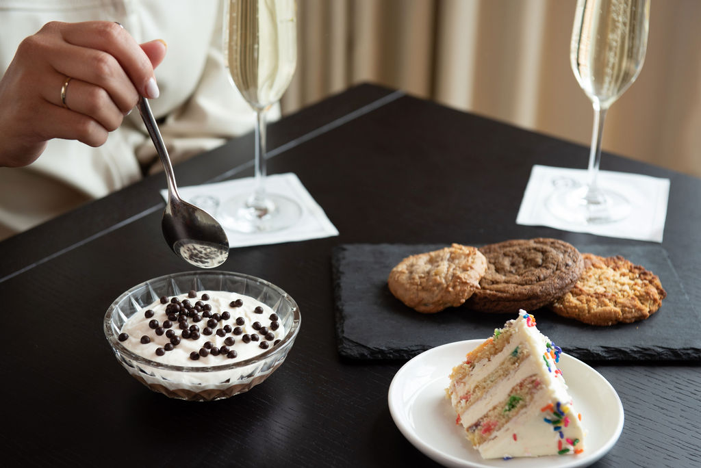 Dessert spread with cookies, cake and chocolate mousse served with champagne at Pendry Manhattan West.