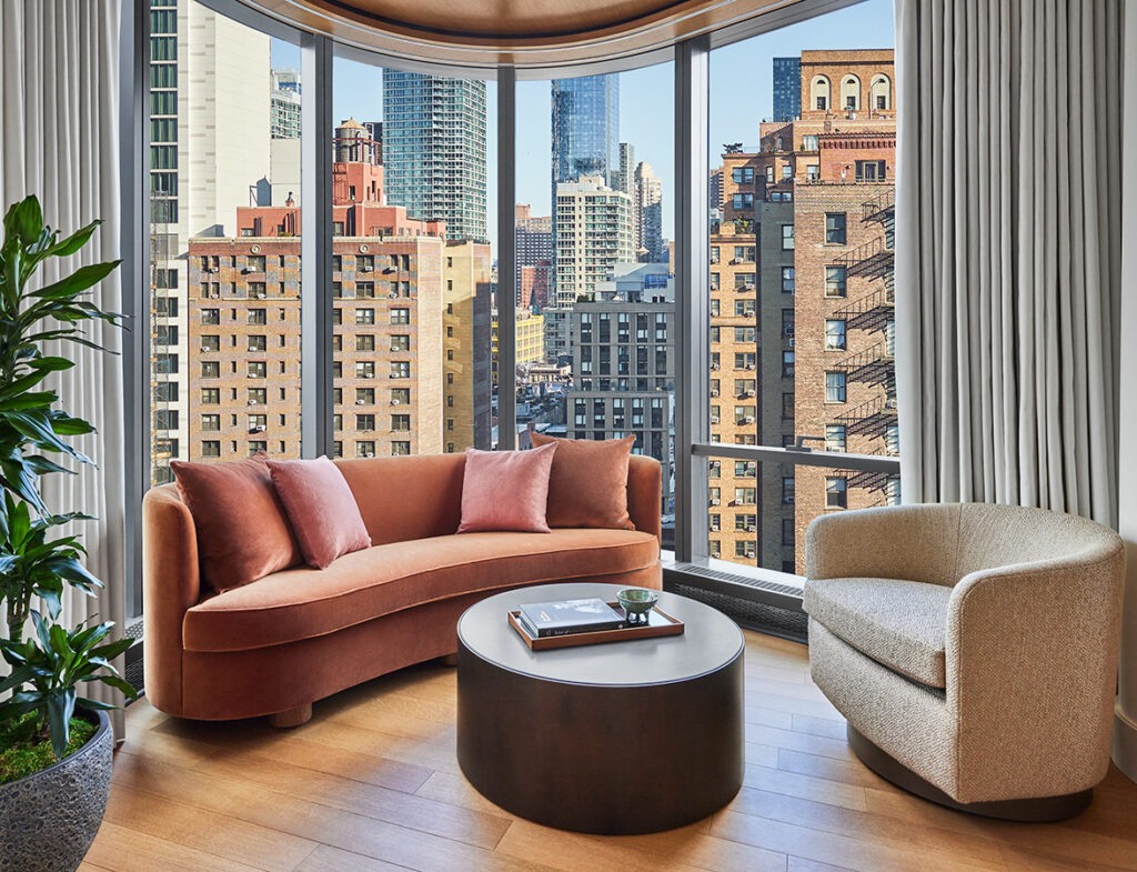 Suite sitting area with floor-to-ceiling windows showcasing a city skyline