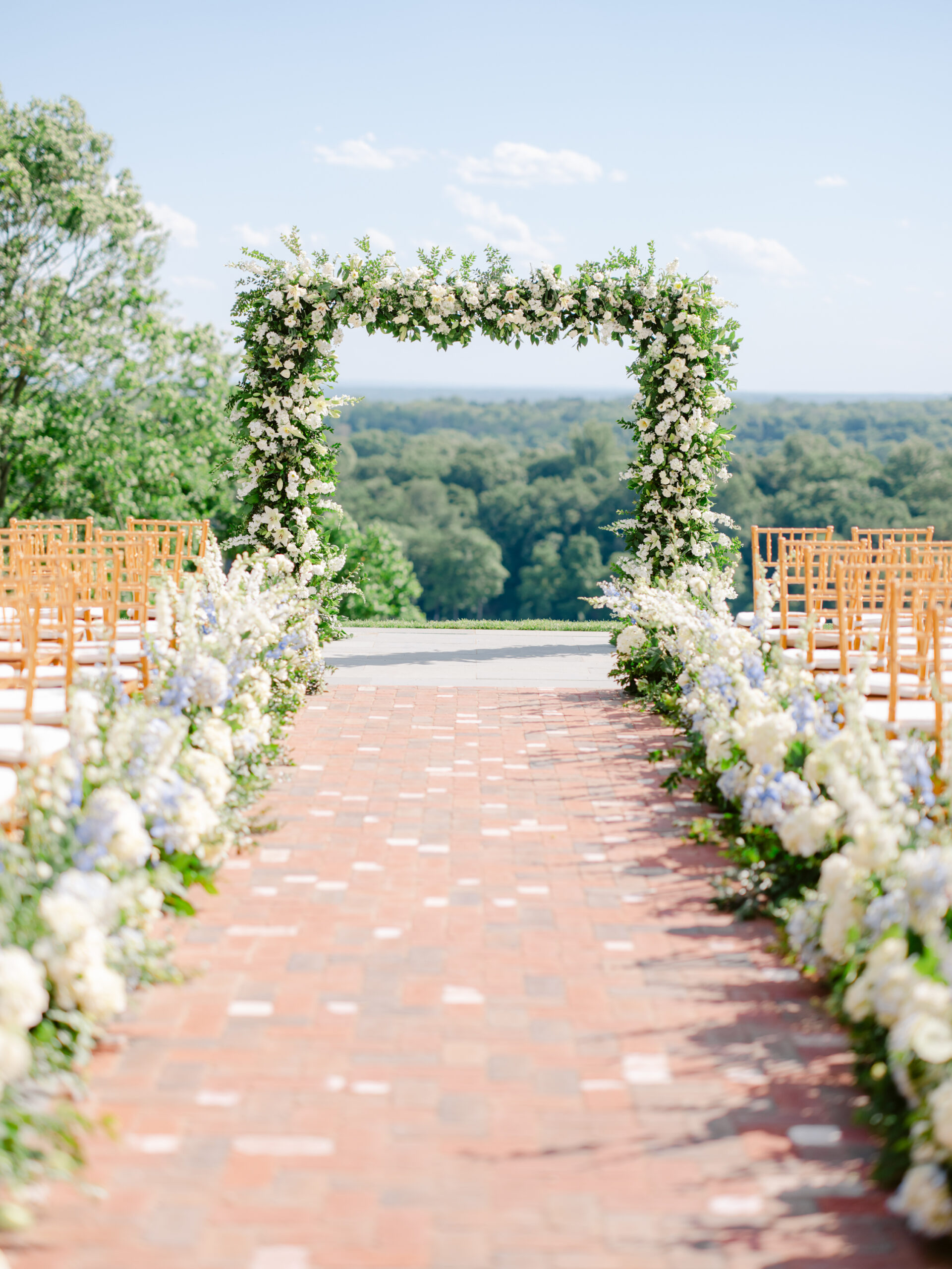 Floral-lined aisle leading to a floral arch at an outdoor wedding venue near NYC.