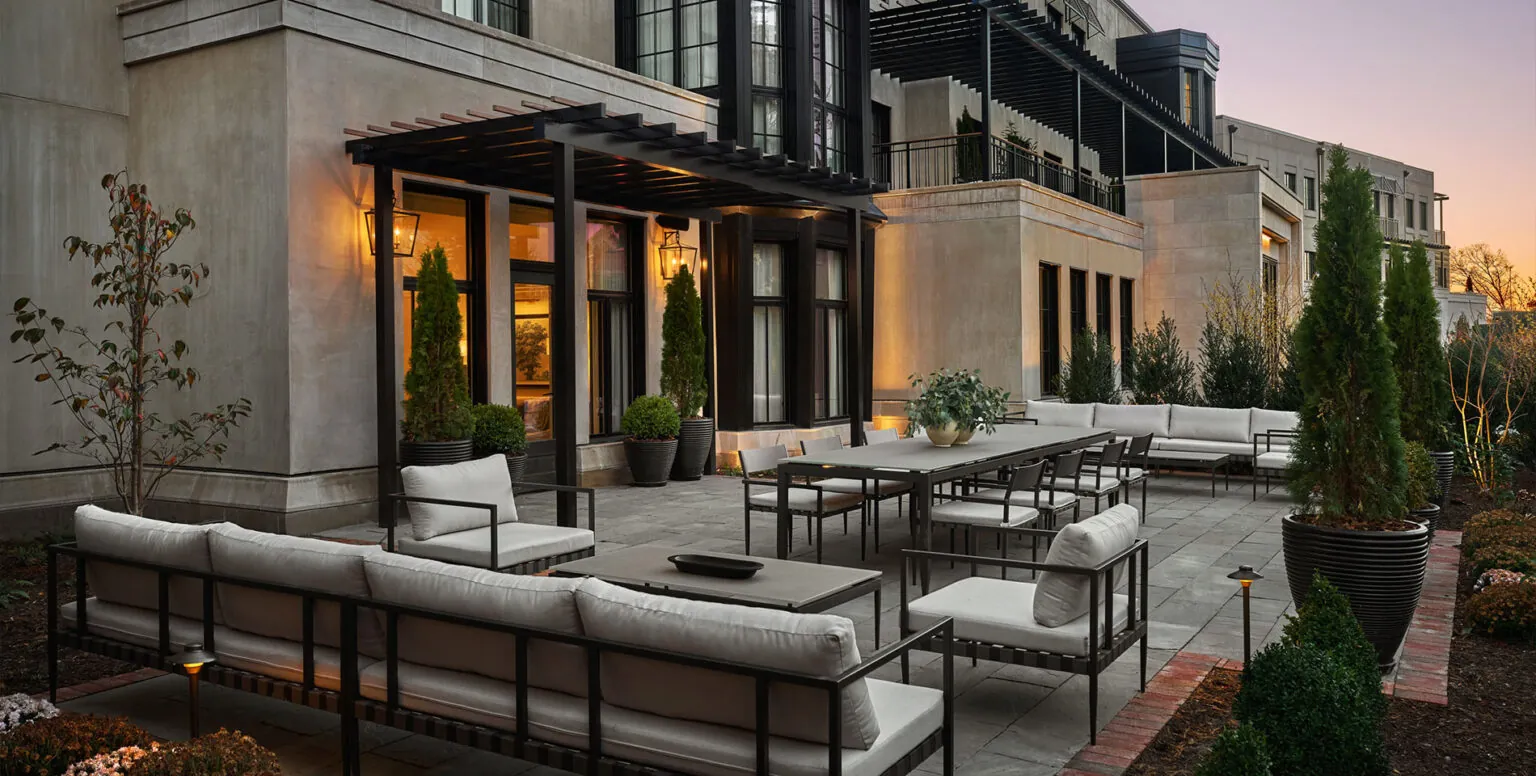 A patio outside of a suite at Pendry Natirar with couches and a dining table