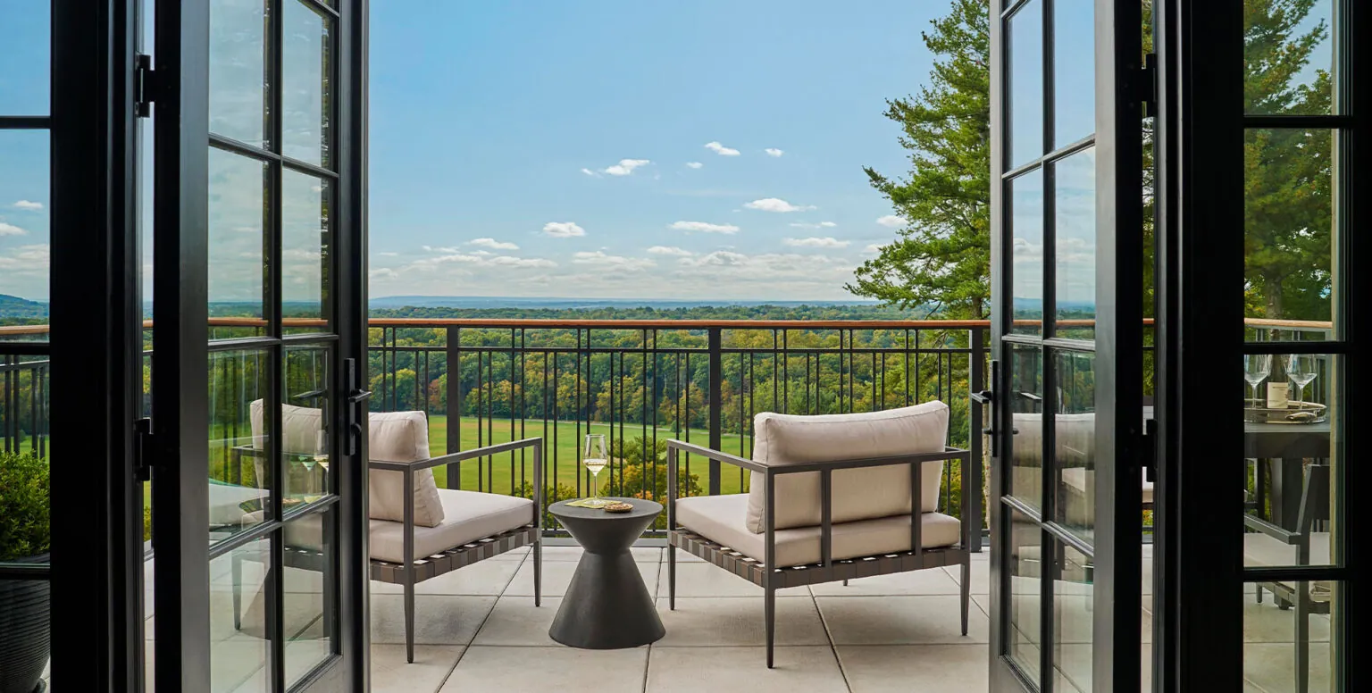 The balcony of a suite with two chairs overlooking the Somerset valley at Pendry Natirar