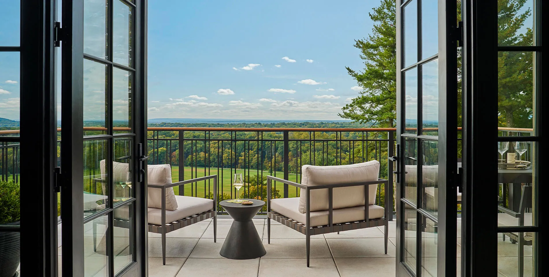 The balcony of a suite with two chairs overlooking the Somerset valley at Pendry Natirar