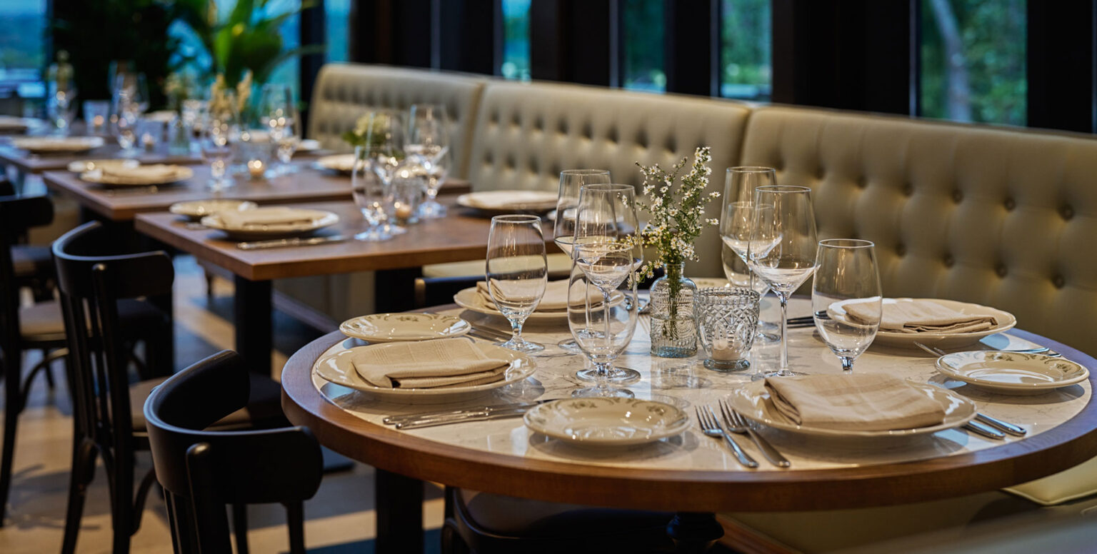 A close up of a dining table with wine glasses, plates and silverware at Ladd’s Tavern