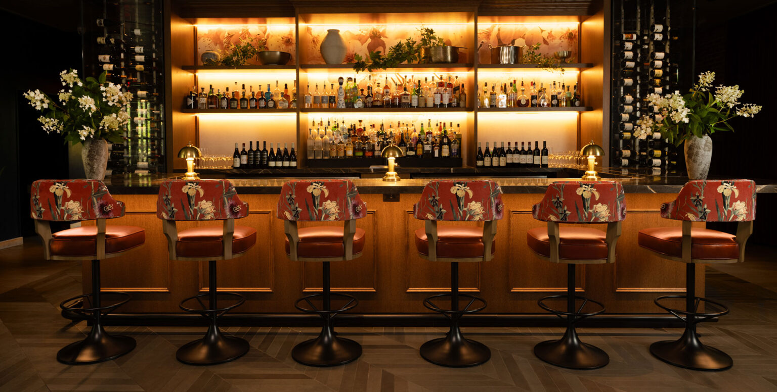 The bar at Ninety Acres with floral hightop chairs
