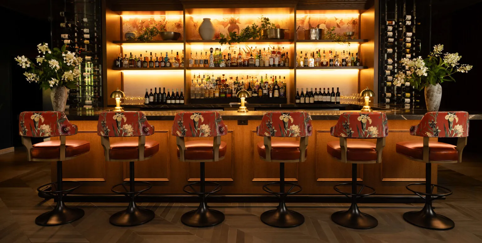 The bar at Ninety Acres with floral hightop chairs