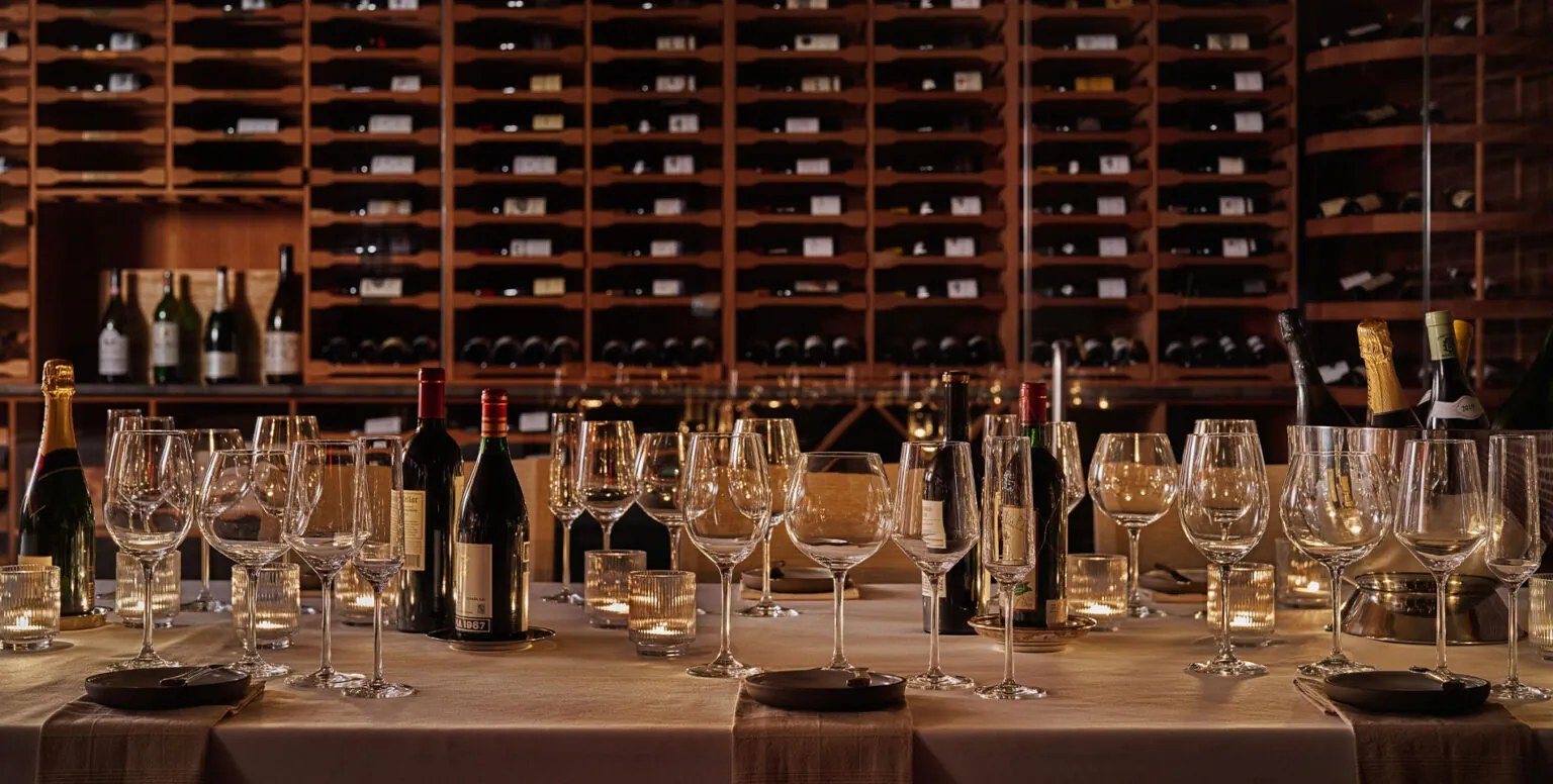 A dining table with wine glasses and wine on it in a wine cellar at Pendry Natirar