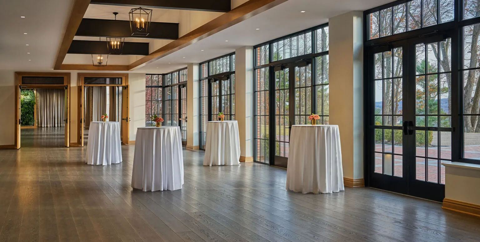 A pre-function room with hightop tables with white tables cloths over them at Pendry Natirar