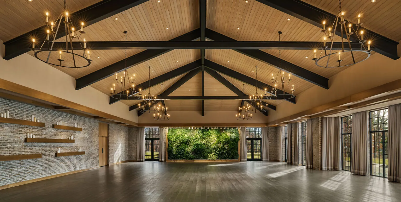 A rustic ballroom with candle chandeliers and brick walls at Pendry Natirar resort