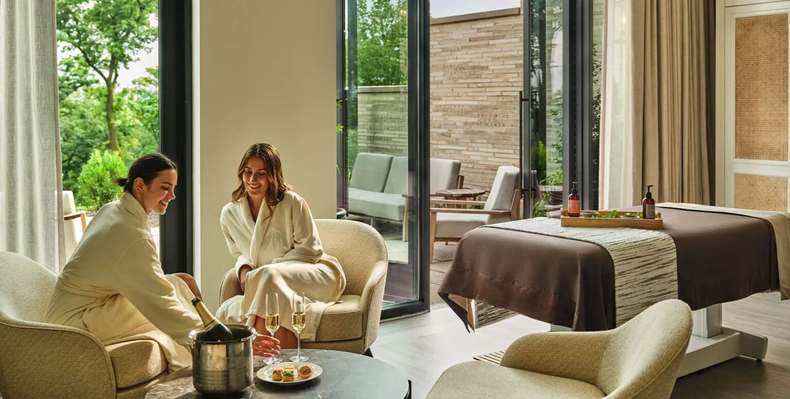 Two women having a glass of champagne in Pendry robes at Spa Pendry Natirar