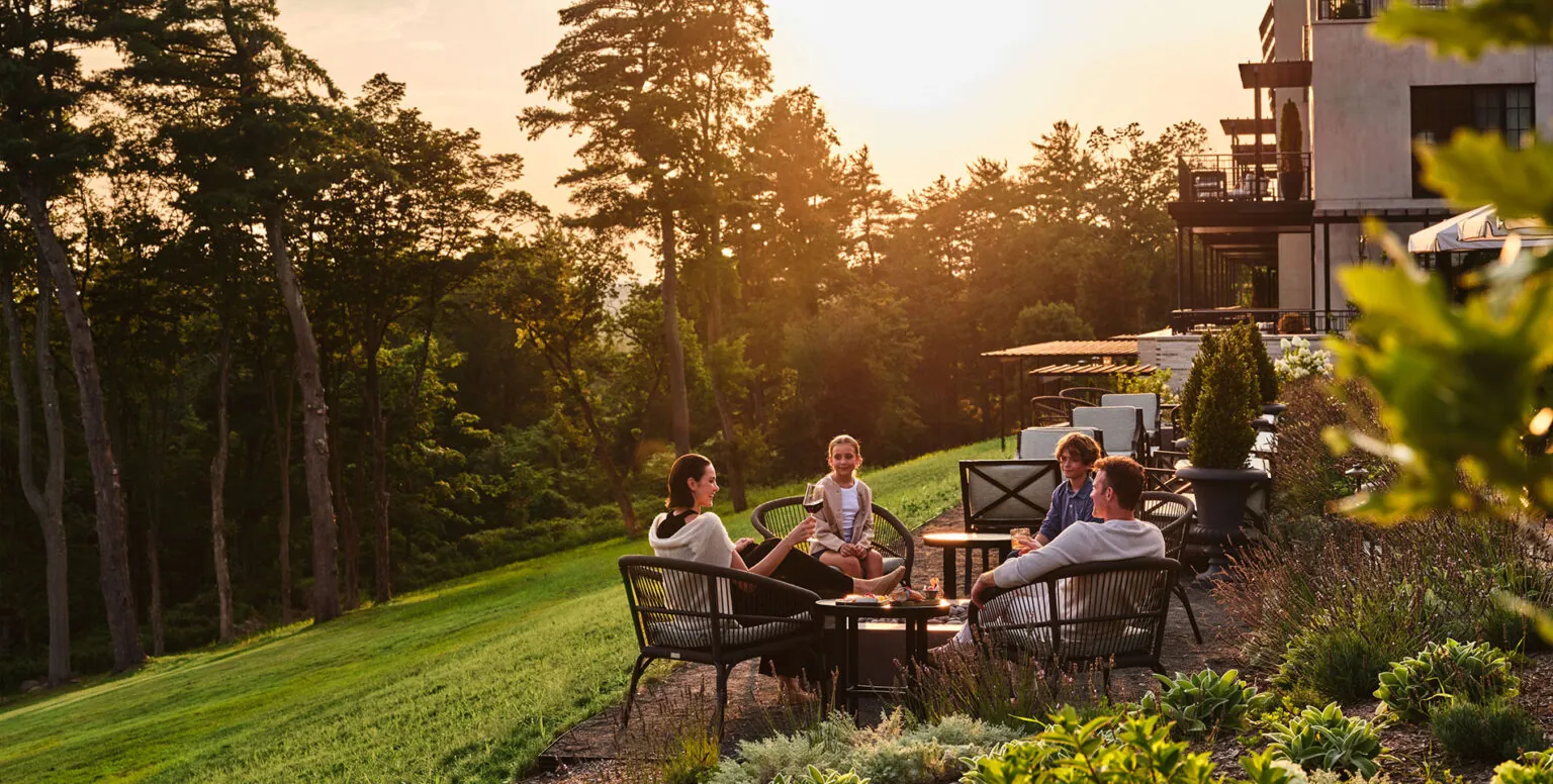 A family of four sitting outside of Pendry Natirar at sunset