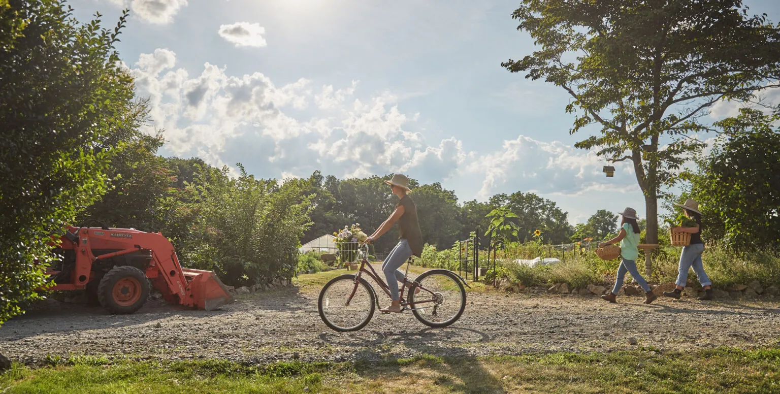 A woman riding a biking on the farm of Pendry Natirar