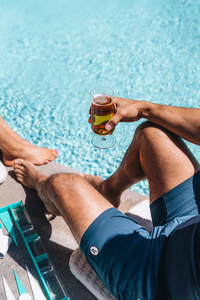 Man Holding a Beer by the Pool