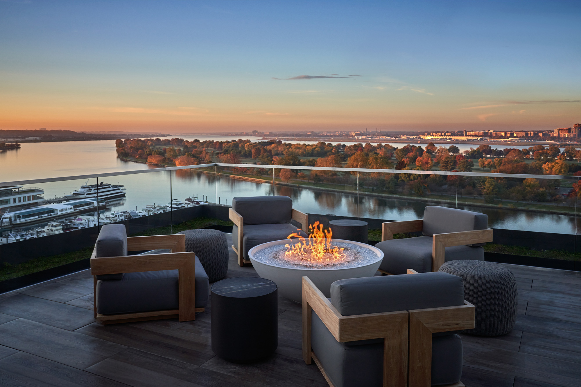 Moonraker South Rooftop terrace at Pendry DC with lounge seating and a fire pit overlooking the waterfront and city skyline at sunset.