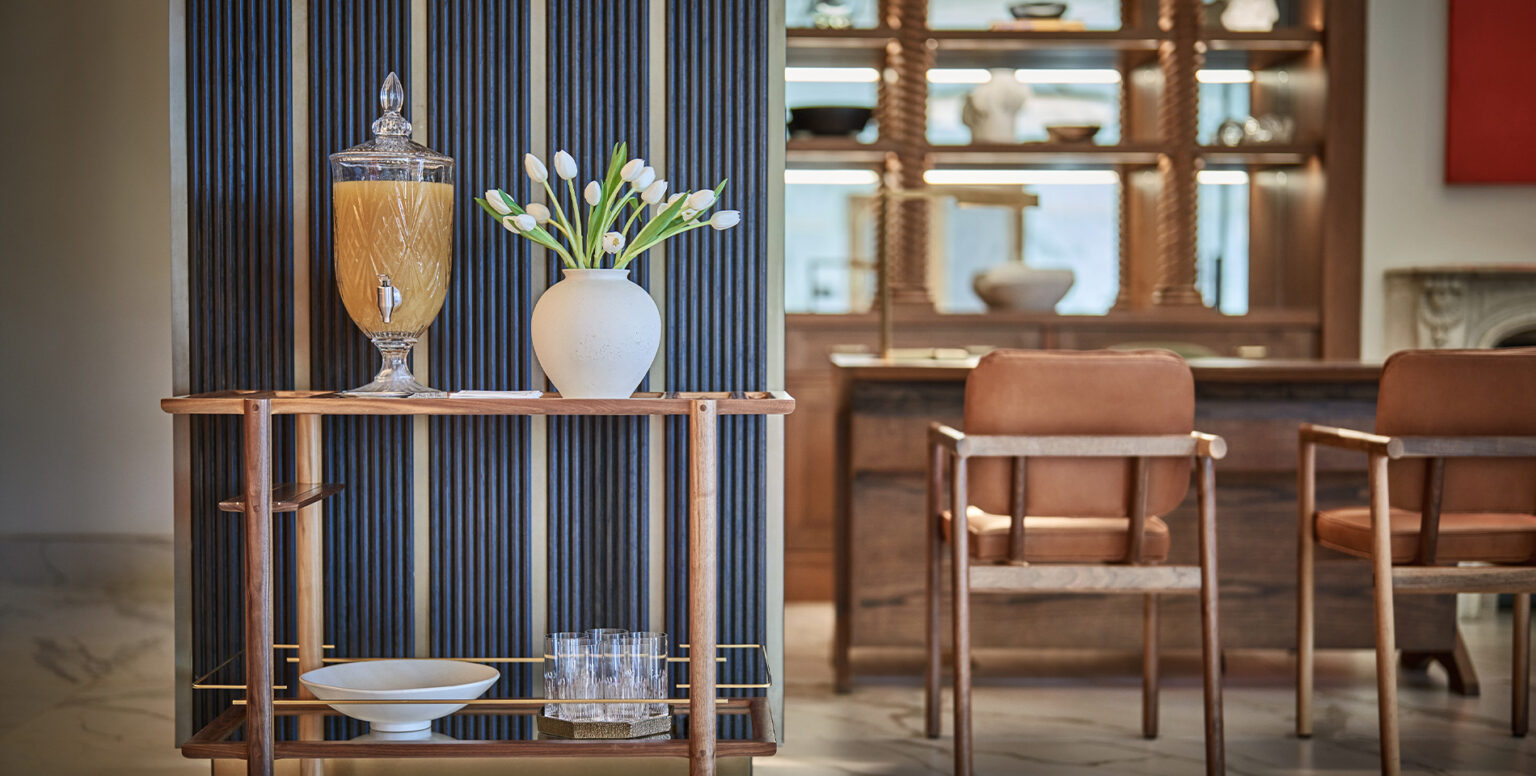 A bar cart with a vase of flowers and a pitcher on it in Pendry Washington DC &ndash; The Wharf