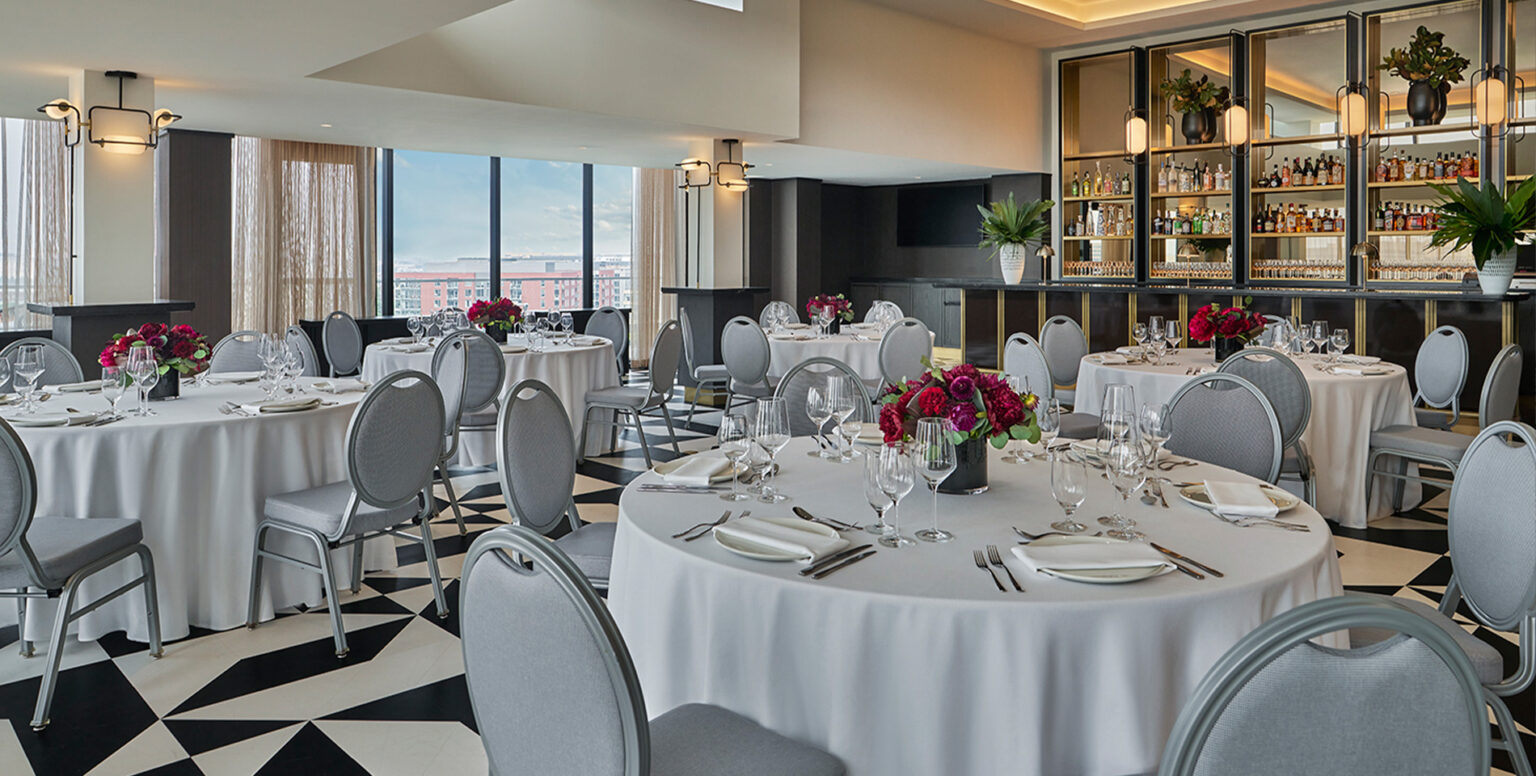 Round tables with white table clothes placed around Moonraker for a DC event