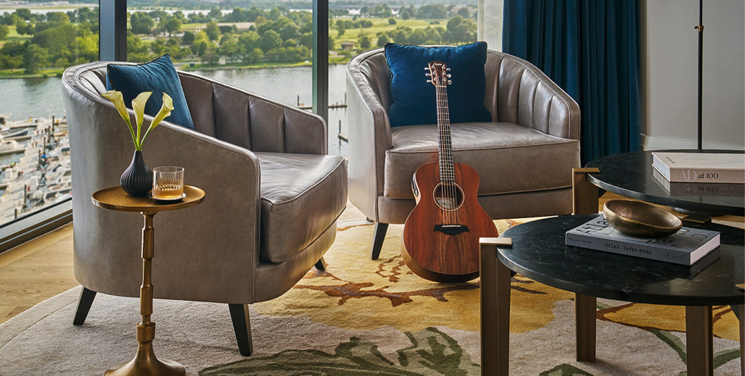 Two chairs in a DC suite with a guitar leaning against one at Pendry Washington DC &ndash; The Wharf