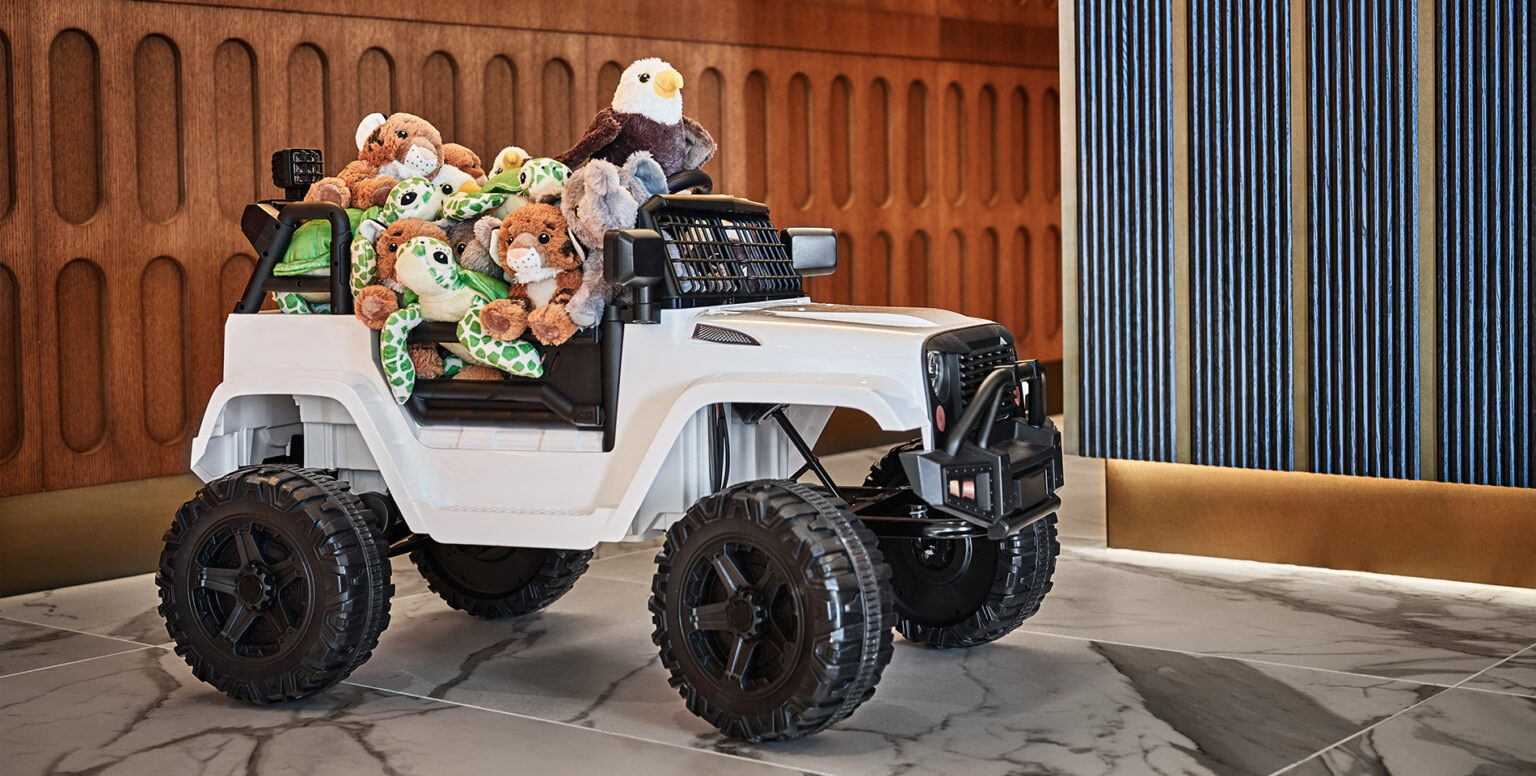 A toy jeep with stuffed animals in it
