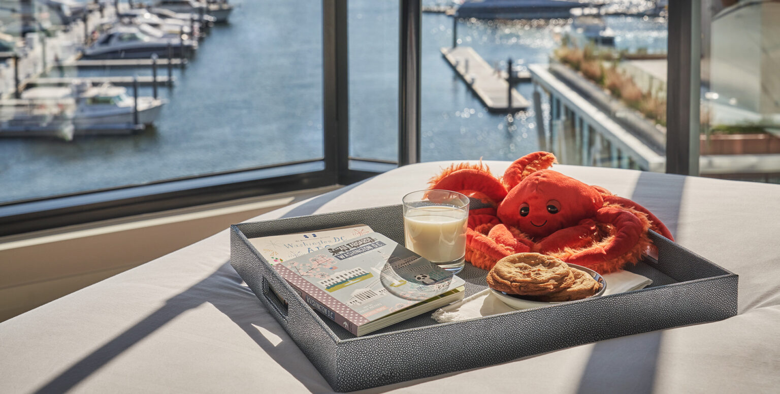 Cookies, milk, a notepad and a toy stuffed lobster on a tray, in a guestroom at Pendry Washington DC &ndash; The Wharf